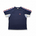 A navy blue short-sleeve athletic t-shirt with a red, white, and blue patterned stripe running along the shoulders and sleeves, and a small red embroidered logo on the left chest, shown flat on a white background.