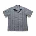 A short-sleeve button-up shirt with vertical gray and white stripes, featuring a pointed collar, white buttons, and a small circular logo on the left chest pocket.