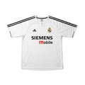 A white Real Madrid soccer jersey by Adidas, featuring black three-stripes on the shoulders, a black zipper at the collar, the Adidas logo on the right chest, the Real Madrid crest on the left chest, and 'SIEMENS mobile' printed across the front.