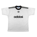 A white Adidas short-sleeve soccer jersey with black stripes on the shoulders, a black Adidas trefoil logo on the chest, and the word 'adidas' in black across the center, shown against a plain white background.