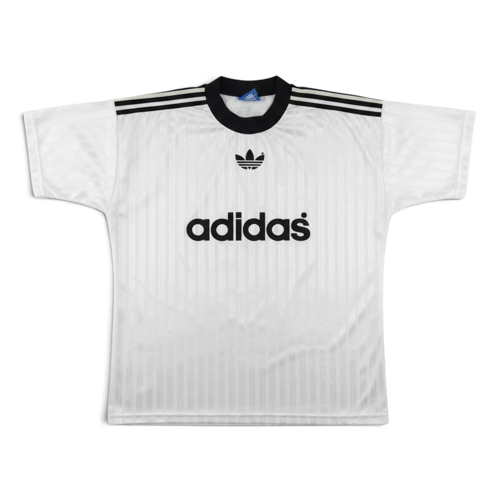 A white Adidas short-sleeve soccer jersey with black stripes on the shoulders, a black Adidas trefoil logo on the chest, and the word 'adidas' in black across the center, shown against a plain white background.